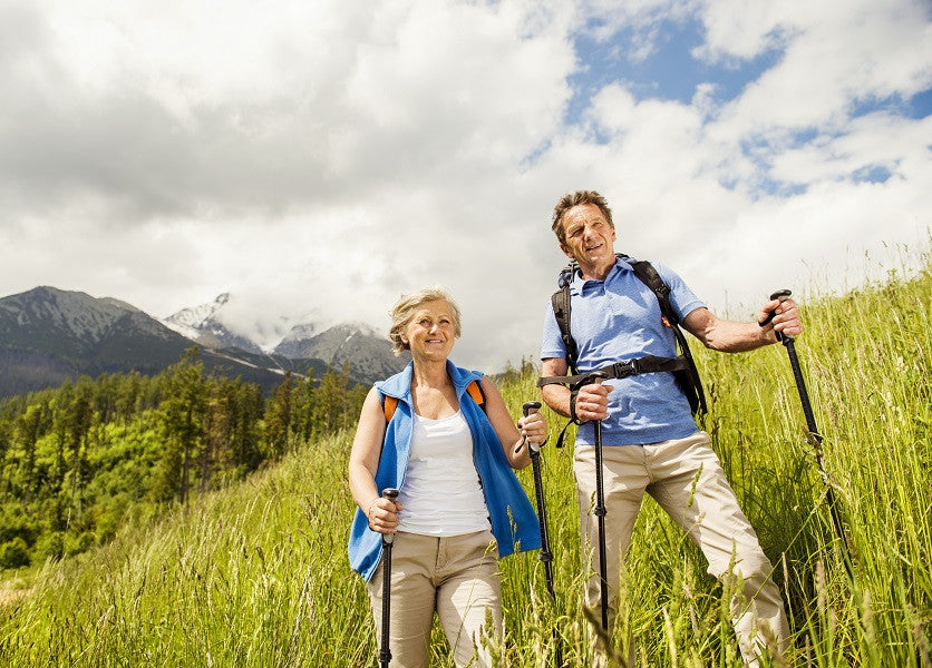 Couple hiking in a field with mountains in the background