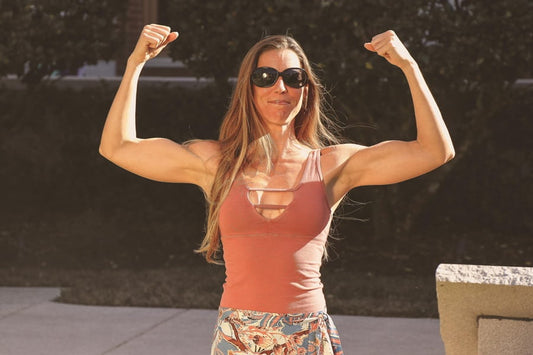 A woman holding her arms up to either side of her body, flexing her muscles